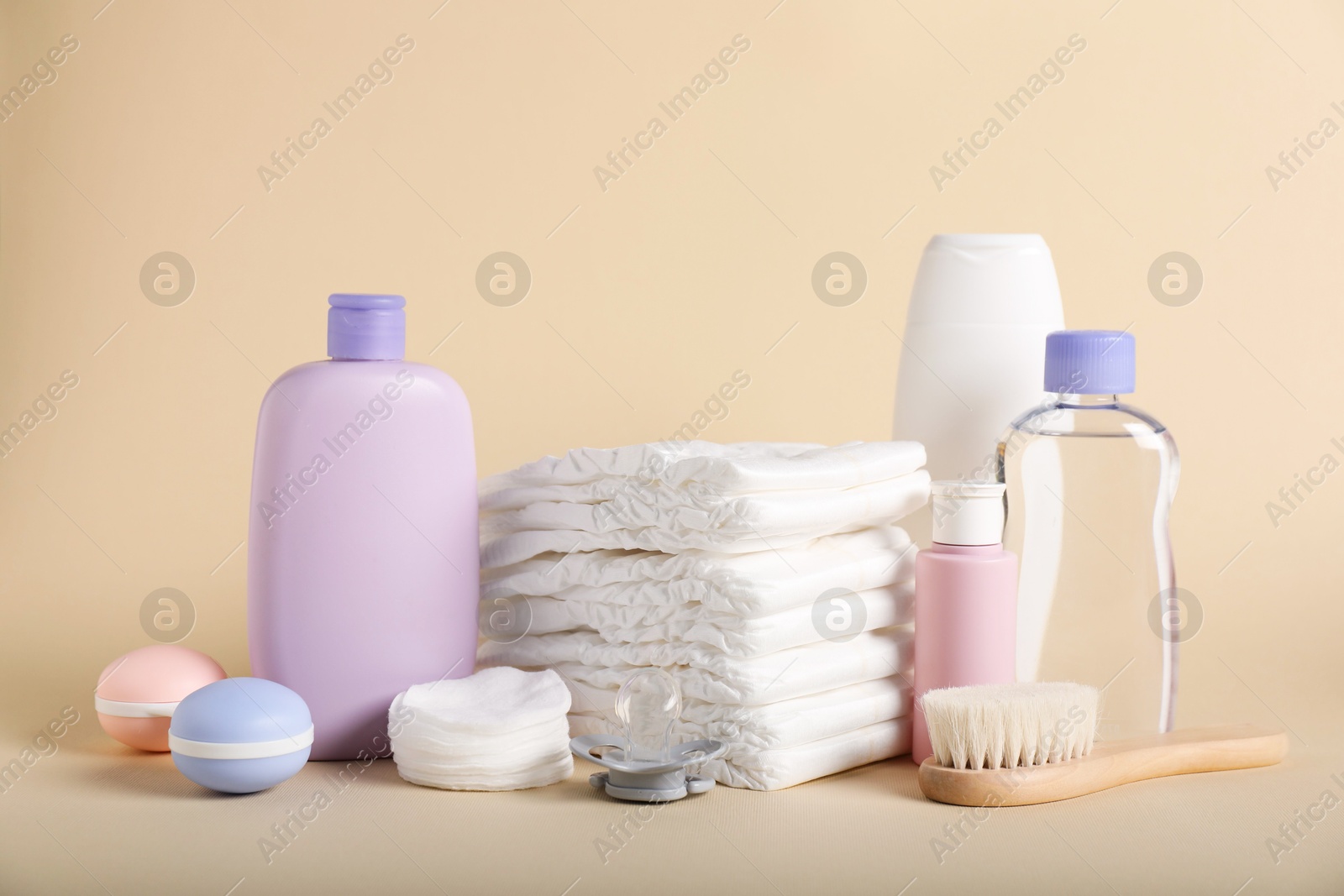 Baby accessories and cosmetic products on beige background Photo of Baby accessories and cosmetic products on beige background