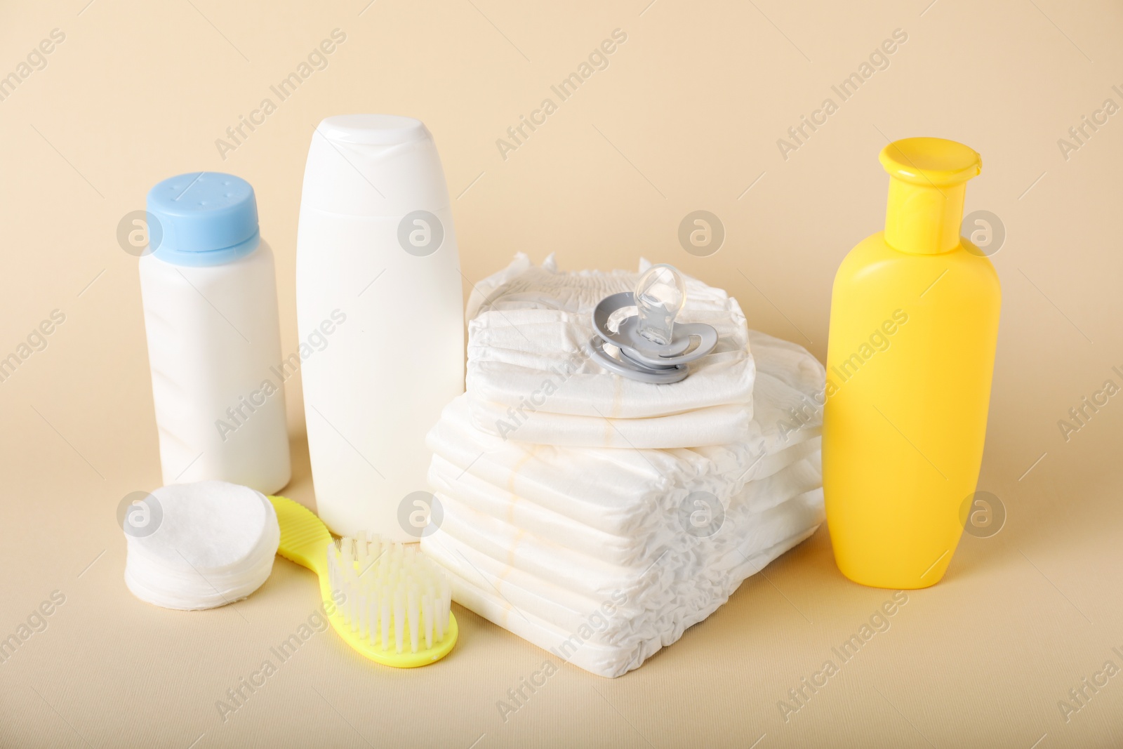 Baby accessories and cosmetic products on beige background Photo of Baby accessories and cosmetic products on beige background