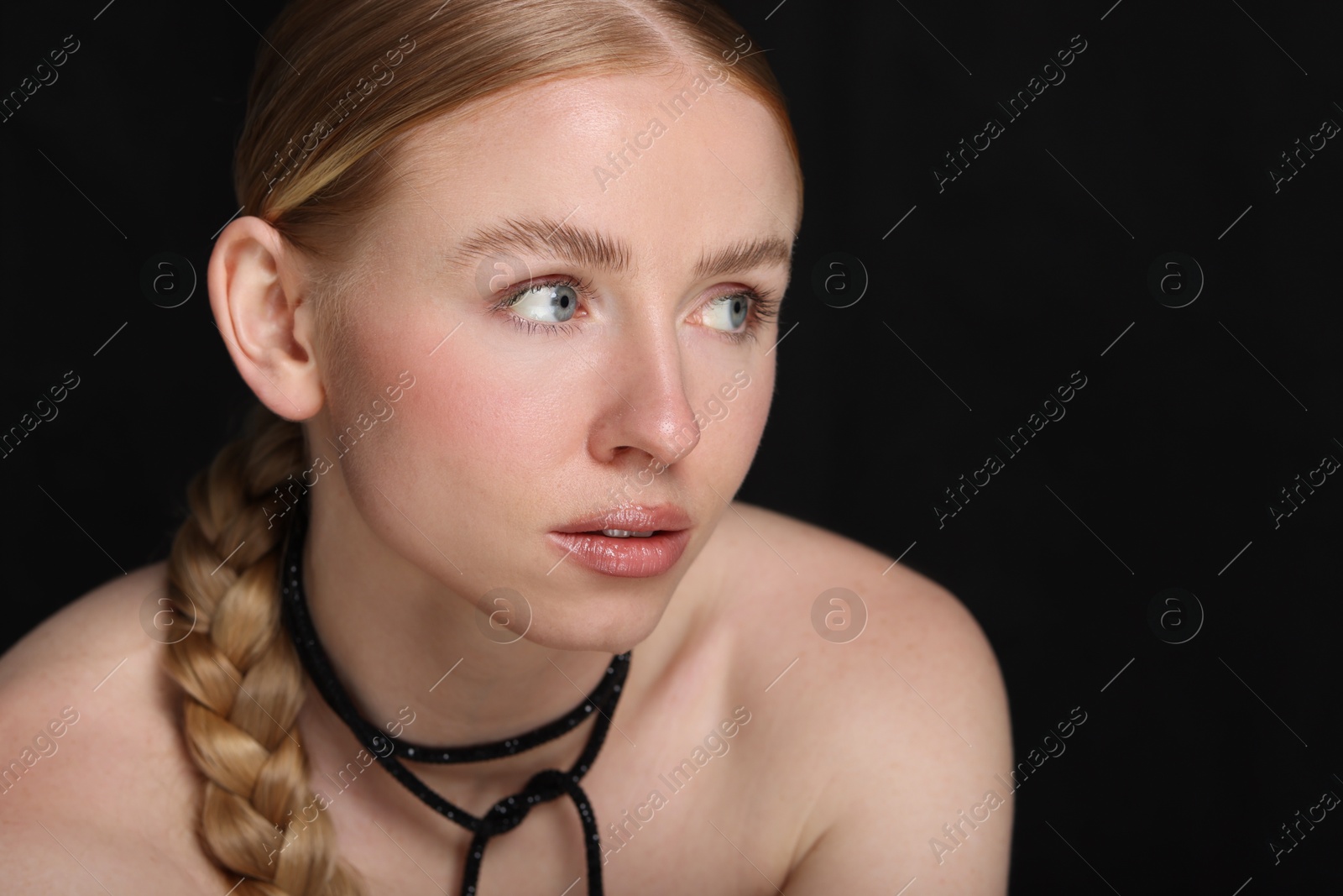 Beautiful woman with pigtail on black background, closeup Photo of Beautiful woman with pigtail on black background, closeup