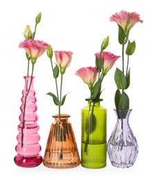 Photo of Beautiful eustoma flowers in glass vases isolated on white