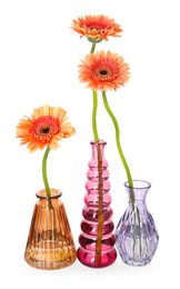 Photo of Beautiful gerbera flowers in glass vases isolated on white