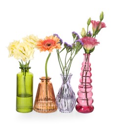 Photo of Different beautiful flowers in glass vases isolated on white