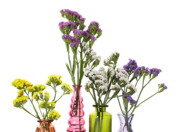 Photo of Different beautiful flowers in glass vases isolated on white