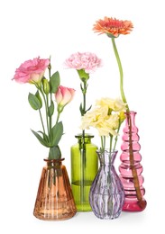 Photo of Different beautiful flowers in glass vases isolated on white