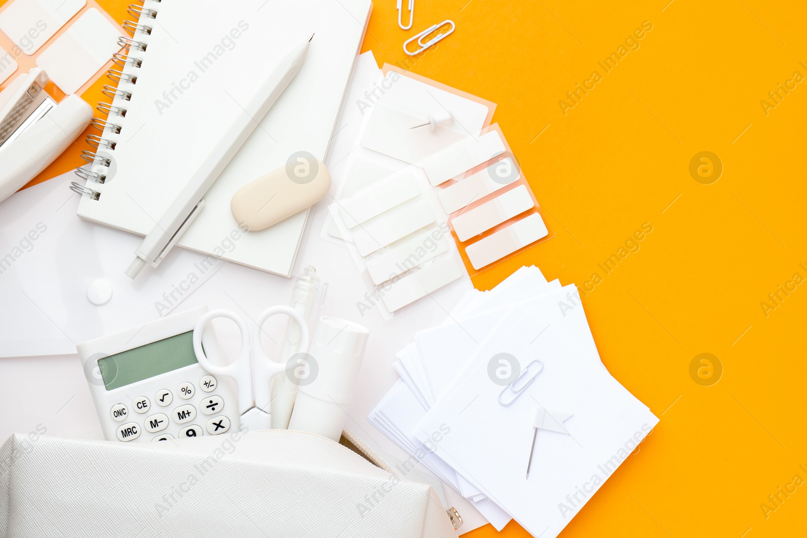 Photo of White stationery on orange background, flat lay. Space for text