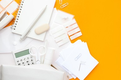 Photo of White stationery on orange background, flat lay. Space for text