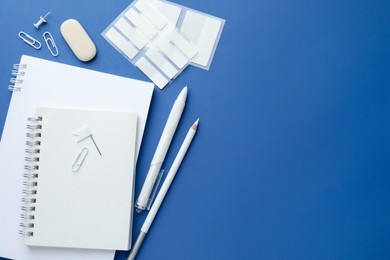 Photo of White stationery on blue background, flat lay. Space for text