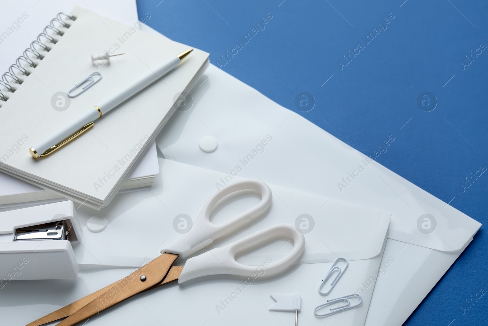 Stationery in white color on blue background, closeup Photo of Stationery in white color on blue background, closeup