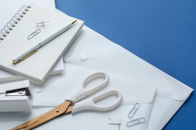 Photo of Stationery in white color on blue background, closeup