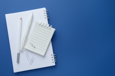 Photo of White stationery on blue background, flat lay. Space for text