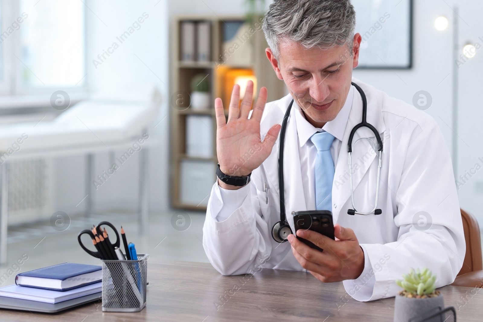 Telemedicine. Doctor having video call with patient via smartphone indoors Photo of Telemedicine. Doctor having video call with patient via smartphone indoors