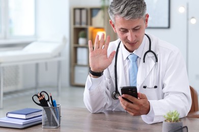 Photo of Telemedicine. Doctor having video call with patient via smartphone indoors