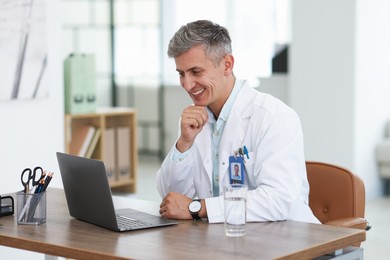 Photo of Telemedicine. Doctor having video call with patient via laptop indoors