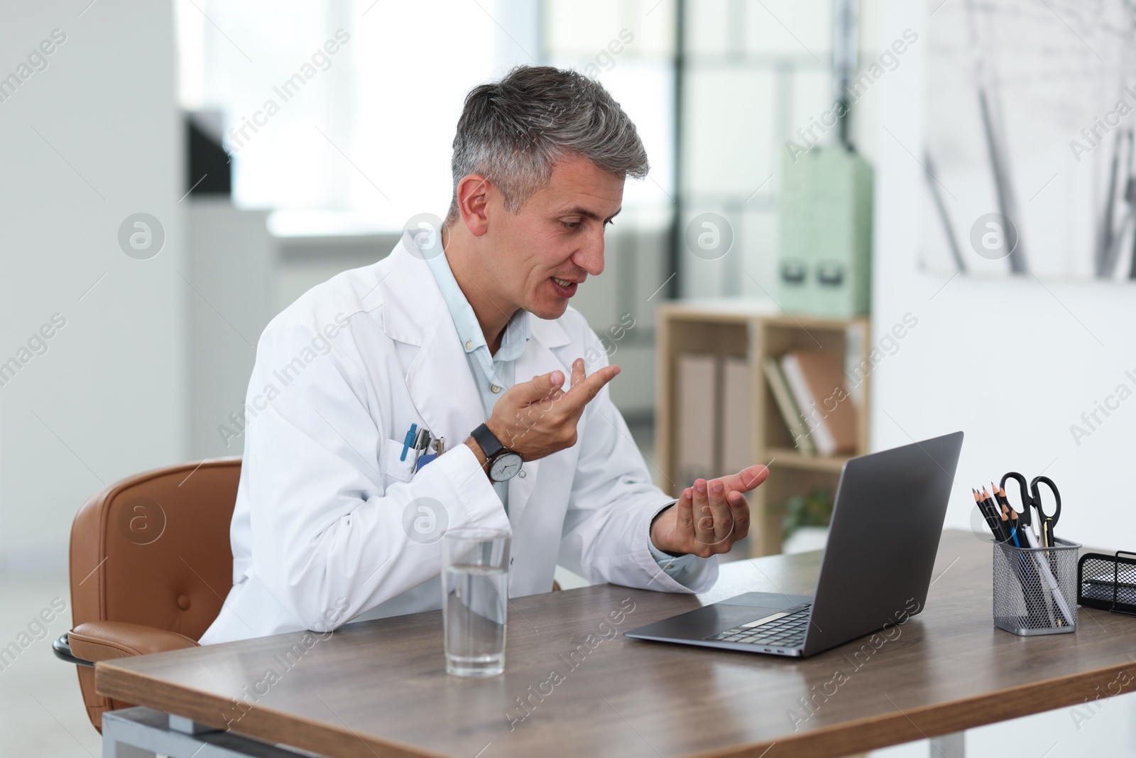 Telemedicine. Doctor having video call with patient via laptop indoors Photo of Telemedicine. Doctor having video call with patient via laptop indoors