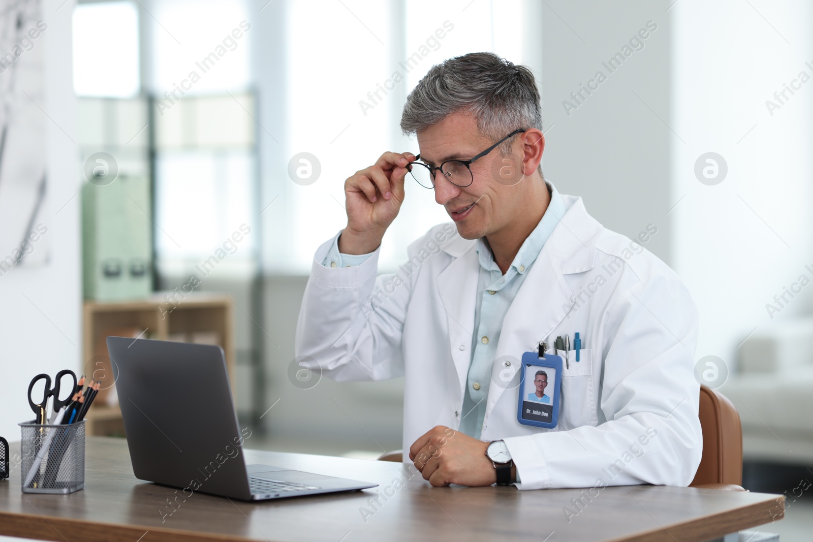 Telemedicine. Doctor having video call with patient via laptop indoors Photo of Telemedicine. Doctor having video call with patient via laptop indoors