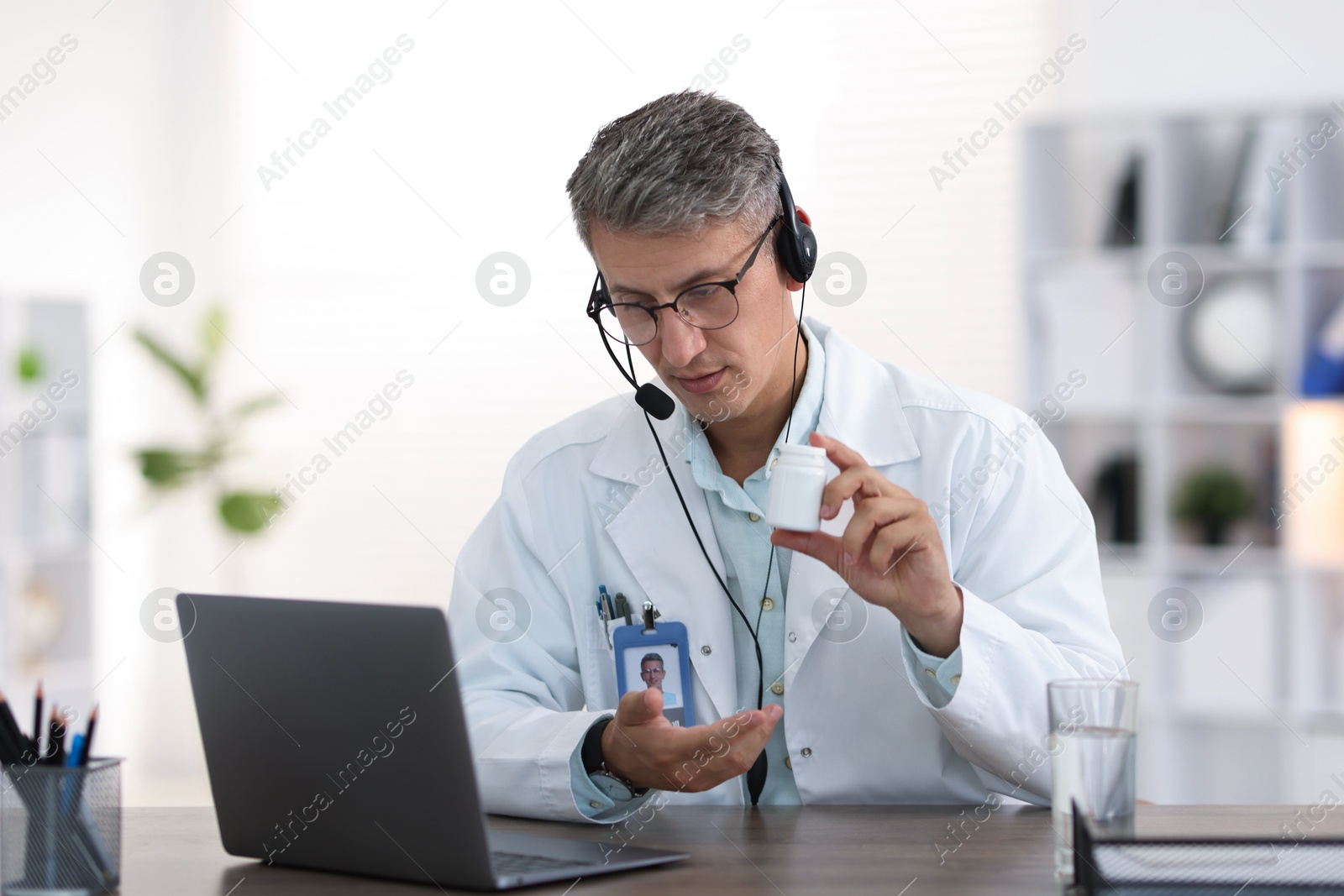 Telemedicine. Doctor recommending pills to patient during video call via laptop indoors Photo of Telemedicine. Doctor recommending pills to patient during video call via laptop indoors
