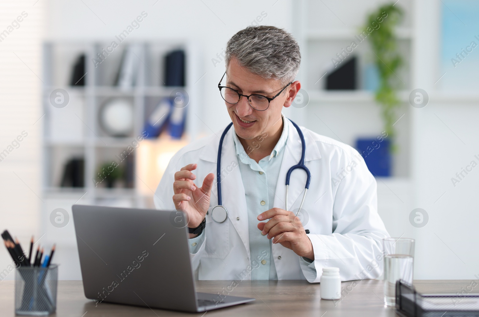 Telemedicine. Doctor having video call with patient via laptop indoors Photo of Telemedicine. Doctor having video call with patient via laptop indoors