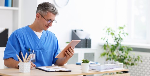 Photo of Telemedicine. Doctor having video call with patient via tablet indoors