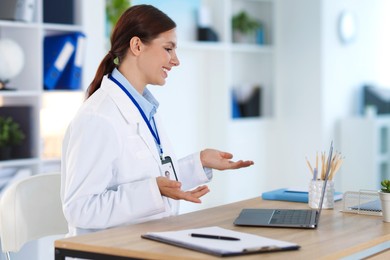 Photo of Telemedicine. Doctor having video call with patient via laptop indoors