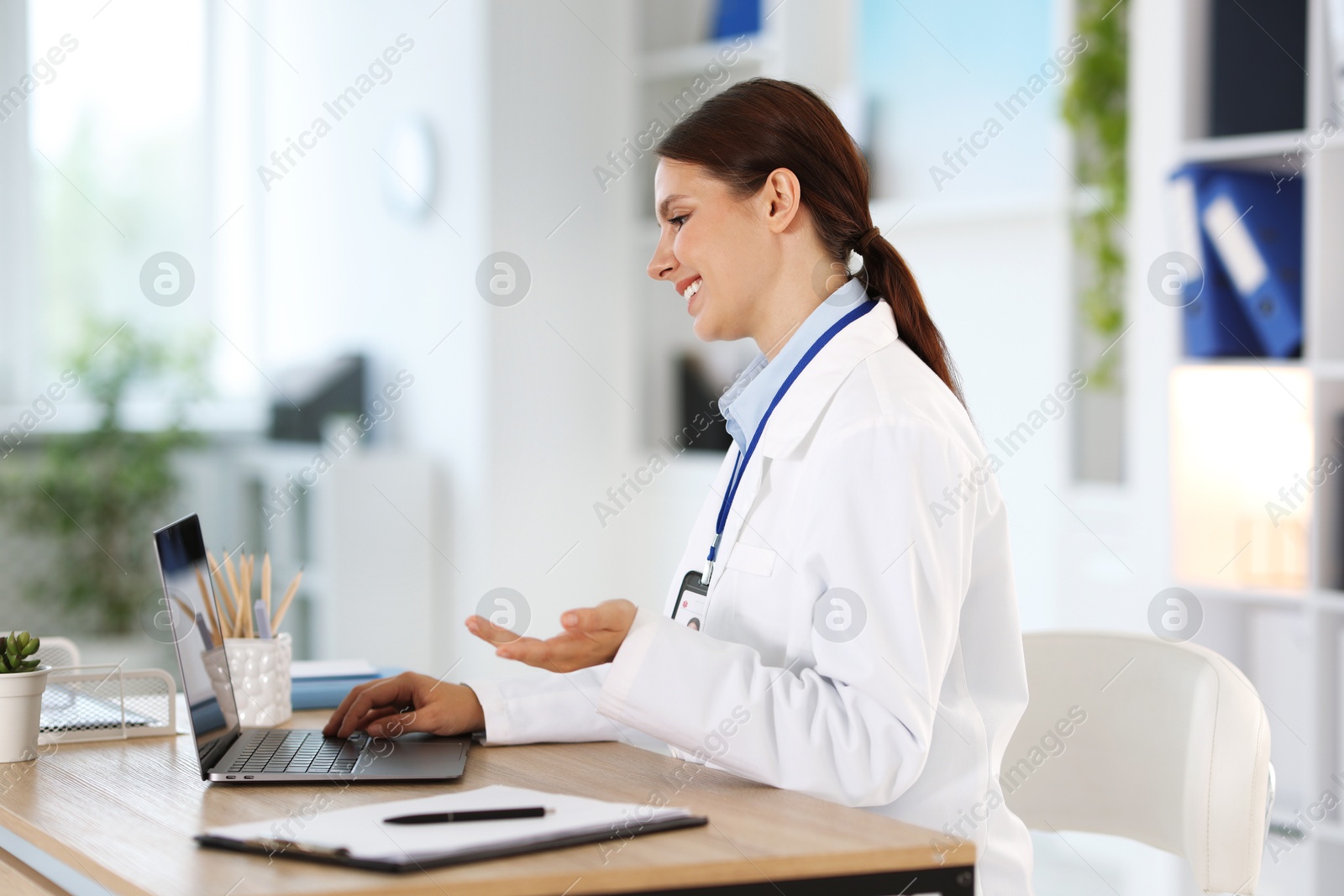 Telemedicine. Doctor having video call with patient via laptop indoors Photo of Telemedicine. Doctor having video call with patient via laptop indoors