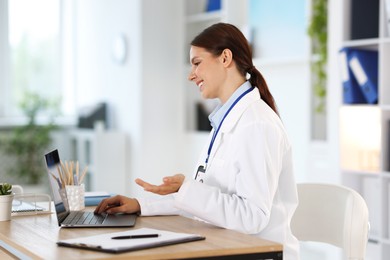 Photo of Telemedicine. Doctor having video call with patient via laptop indoors