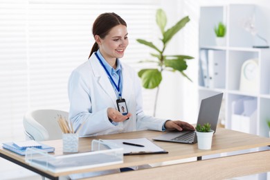Photo of Telemedicine. Doctor having video call with patient via laptop indoors