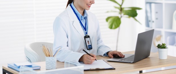 Photo of Telemedicine. Doctor having video call with patient via laptop indoors, closeup