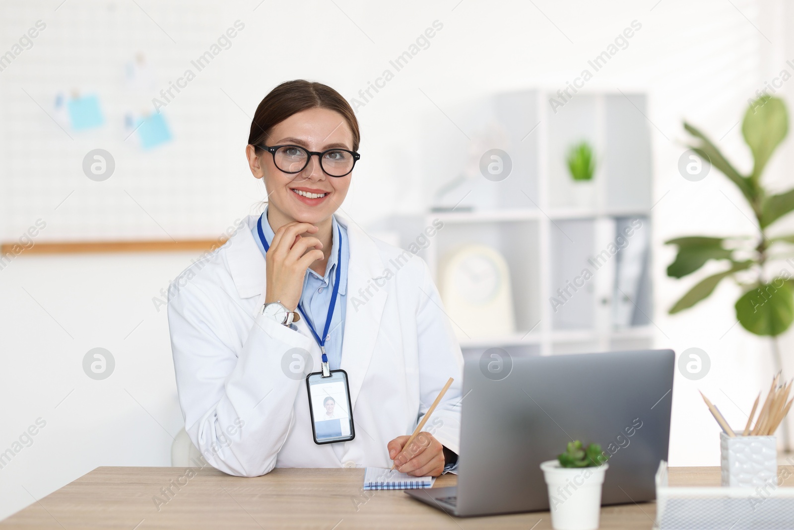 Telemedicine. Doctor making notes while having video call with patient via laptop indoors Photo of Telemedicine. Doctor making notes while having video call with patient via laptop indoors