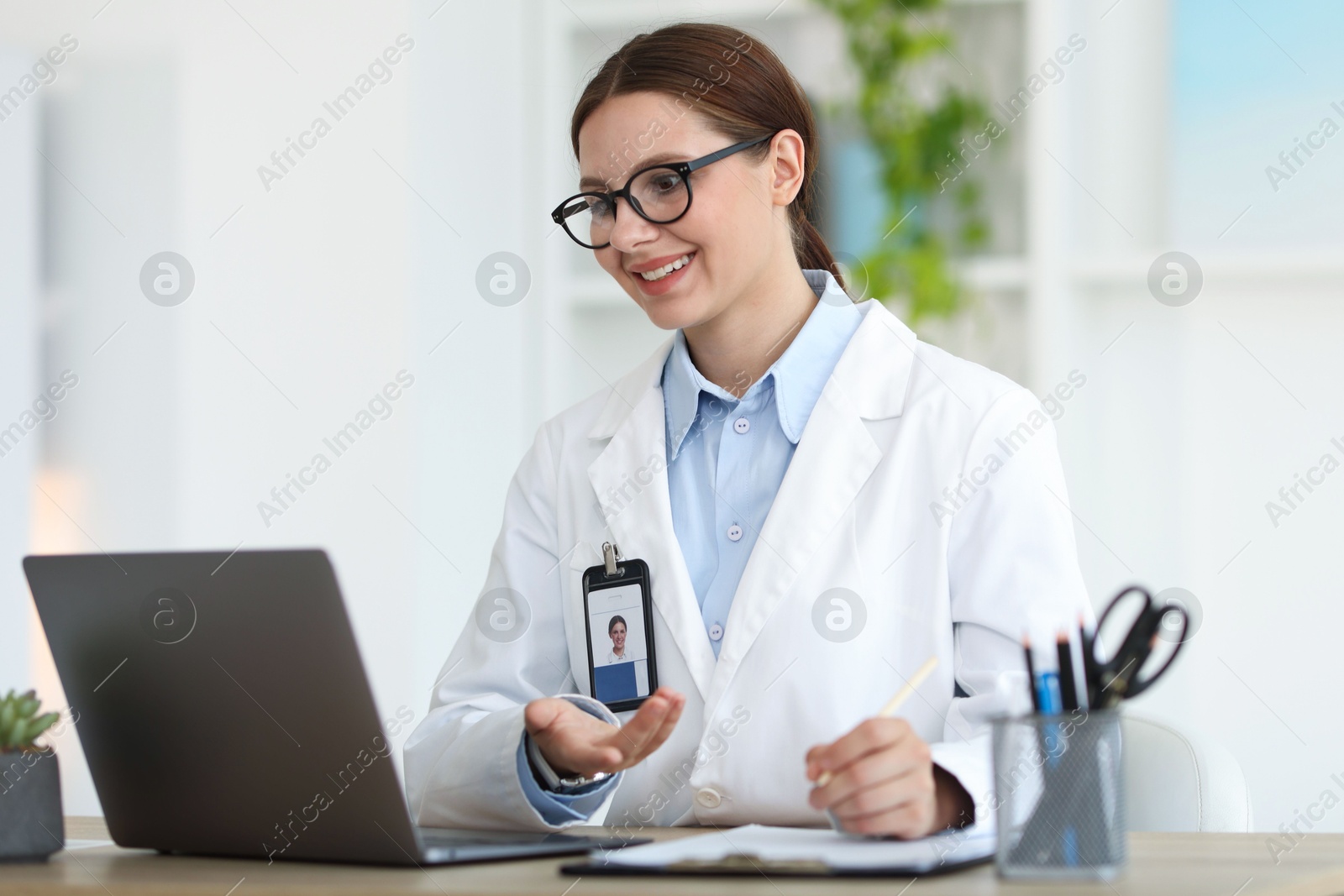 Telemedicine. Doctor having video call with patient via laptop indoors Photo of Telemedicine. Doctor having video call with patient via laptop indoors
