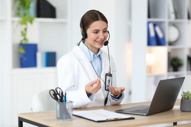 Photo of Telemedicine. Doctor having video call with patient via laptop indoors