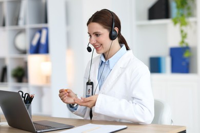 Photo of Telemedicine. Doctor having video call with patient via laptop indoors