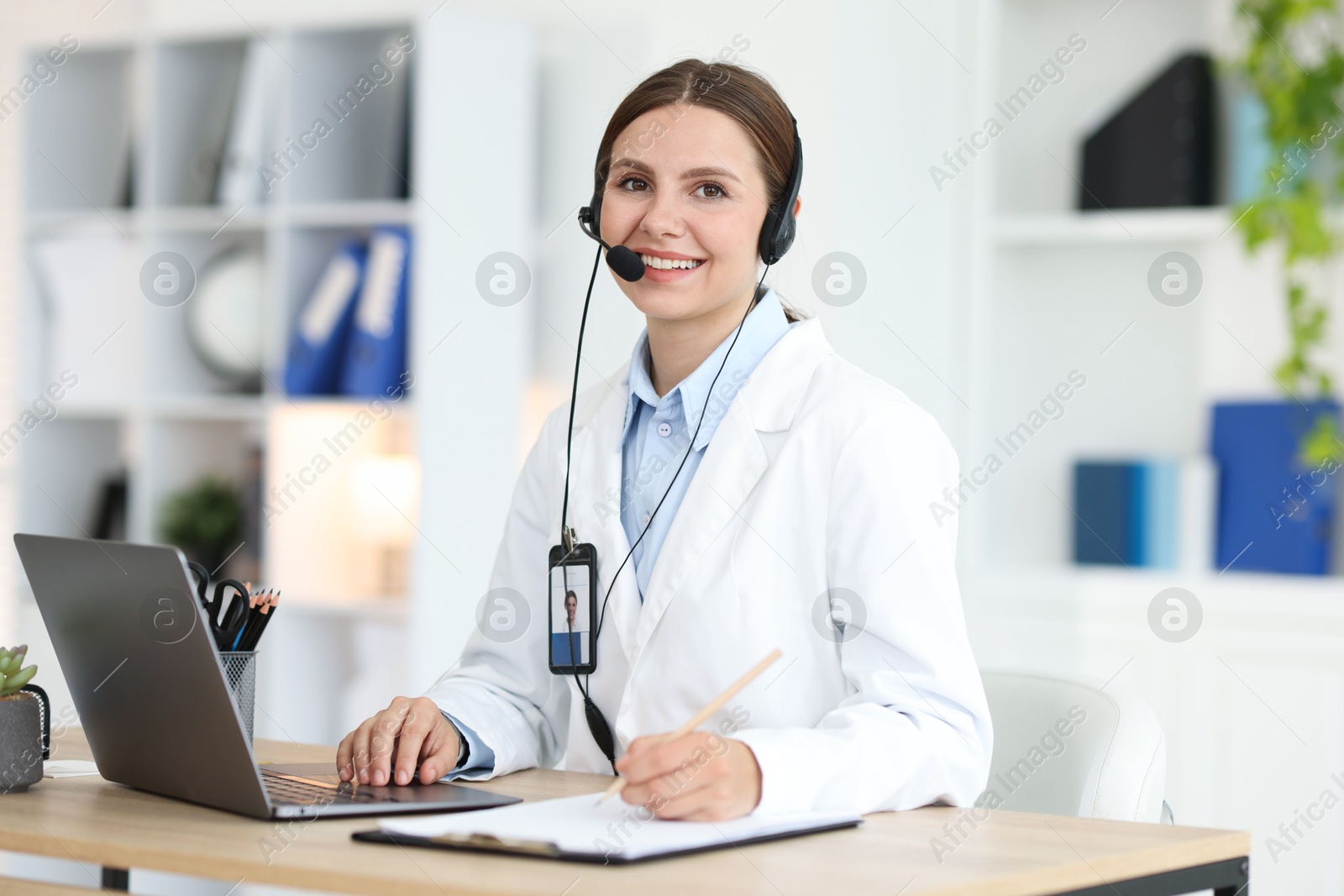 Telemedicine. Doctor making notes while having video call with patient via laptop indoors Photo of Telemedicine. Doctor making notes while having video call with patient via laptop indoors