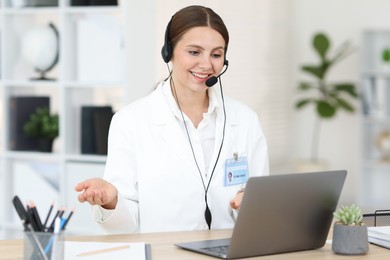 Photo of Telemedicine. Doctor having video call with patient via laptop indoors