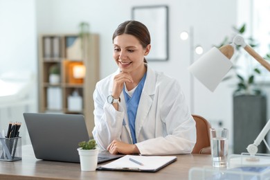 Photo of Telemedicine. Doctor having video call with patient via laptop indoors