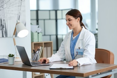 Photo of Telemedicine. Doctor having video call with patient via laptop indoors