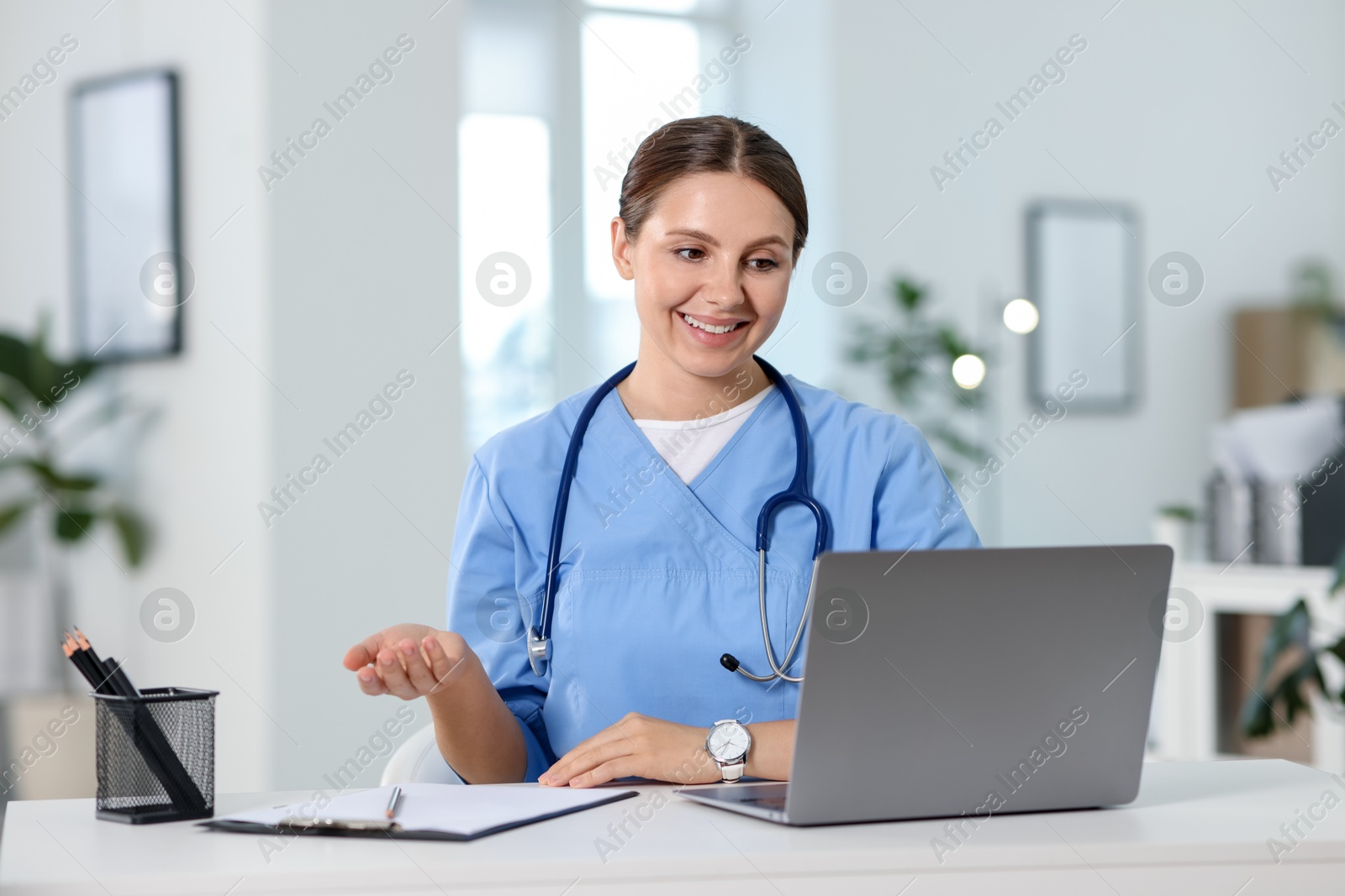Telemedicine. Doctor having video call with patient via laptop indoors Photo of Telemedicine. Doctor having video call with patient via laptop indoors
