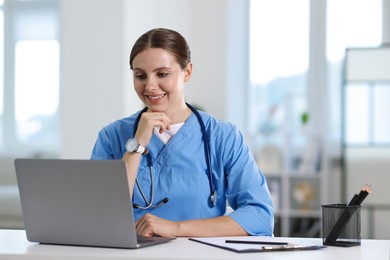 Photo of Telemedicine. Doctor having video call with patient via laptop indoors