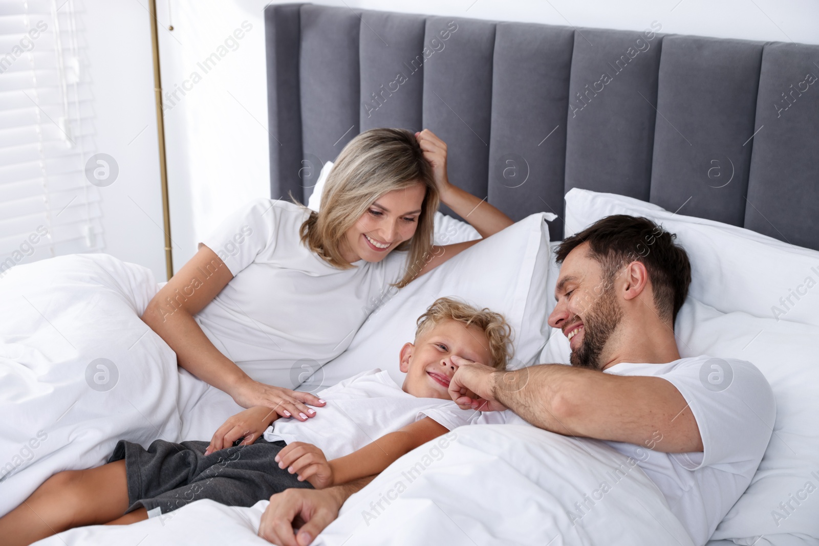 Happy family spending time together on bed at home Photo of Happy family spending time together on bed at home