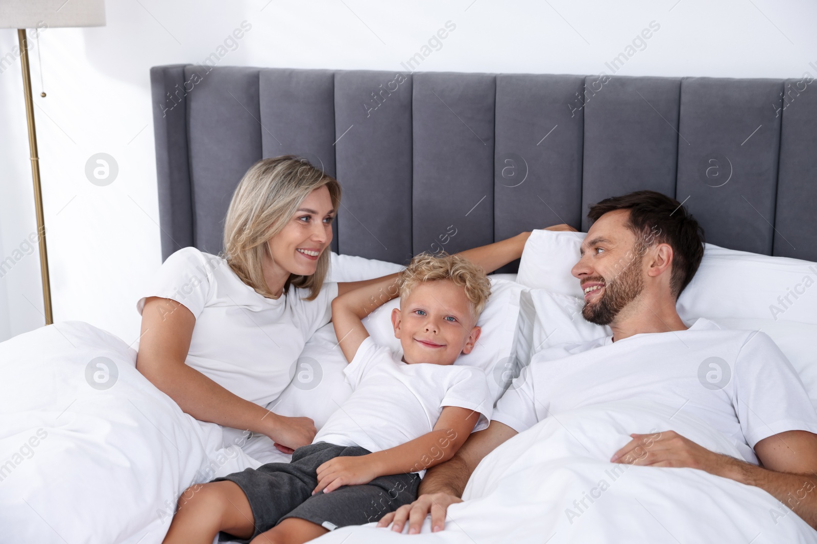 Happy family spending time together on bed at home Photo of Happy family spending time together on bed at home