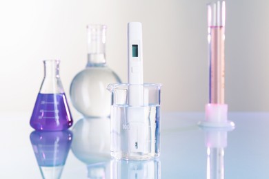 Photo of Nitrate tester in beaker with water and glassware on white table, closeup