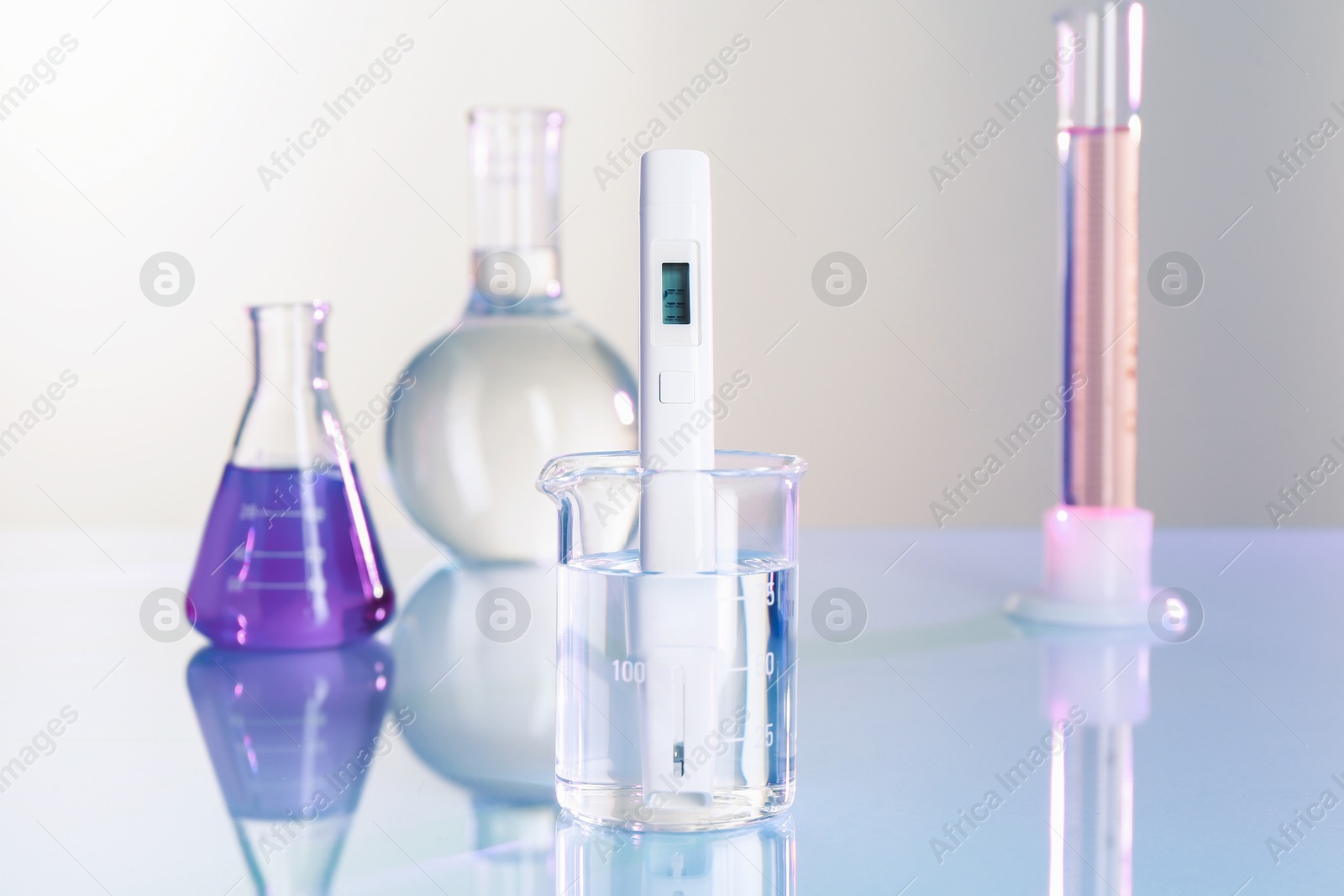 Nitrate tester in beaker with water and glassware on white table, closeup Photo of Nitrate tester in beaker with water and glassware on white table, closeup