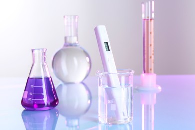 Photo of Nitrate tester in beaker with water and glassware on white table, closeup