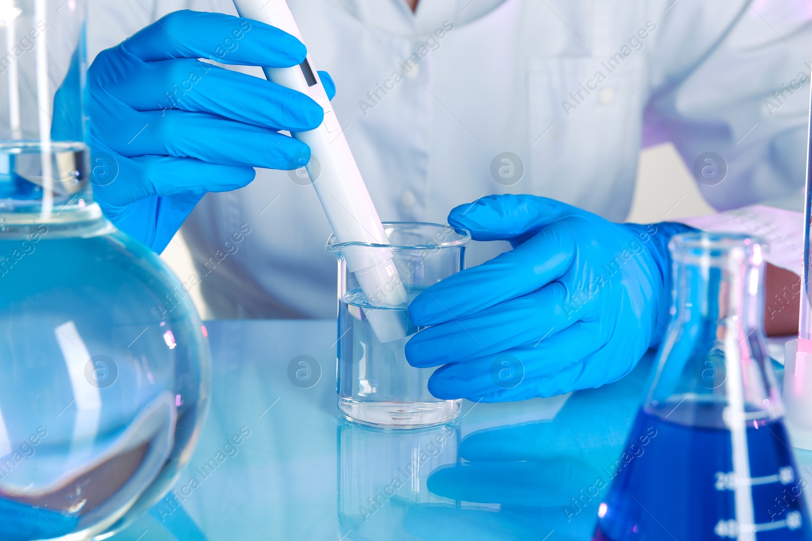 Scientist examining water with nitrate tester at white table in laboratory, closeup Photo of Scientist examining water with nitrate tester at white table in laboratory, closeup