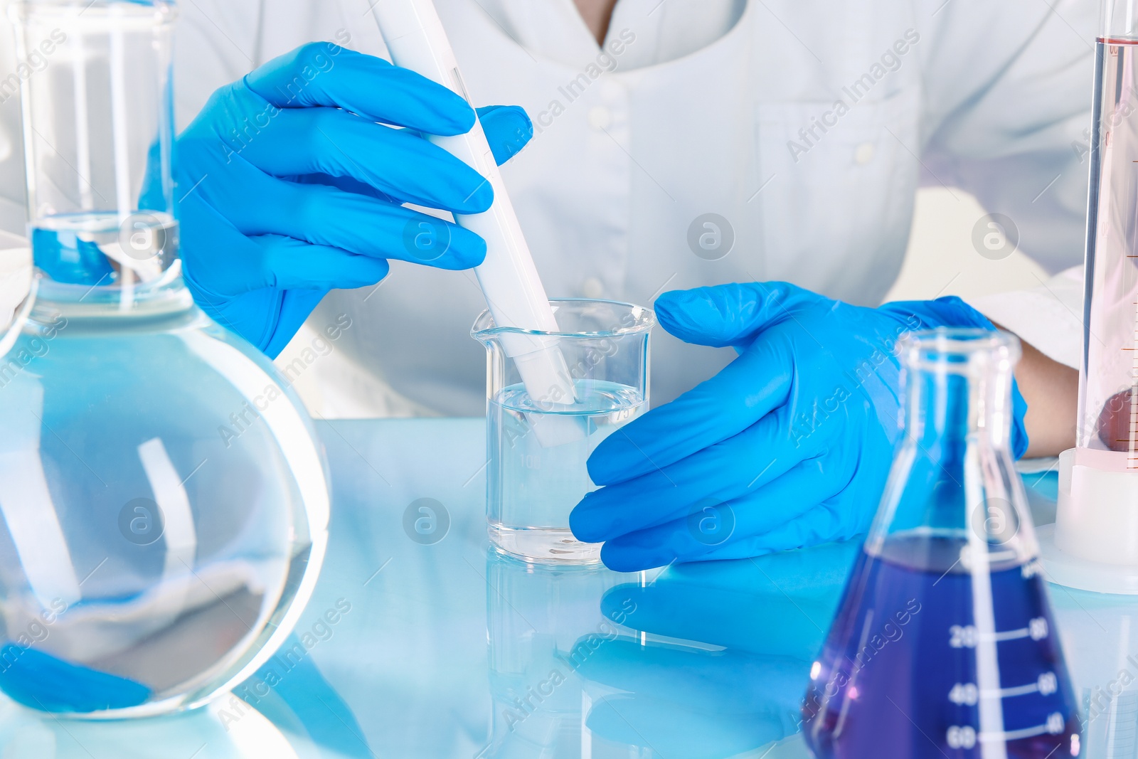 Scientist examining water with nitrate tester at white table in laboratory, closeup Photo of Scientist examining water with nitrate tester at white table in laboratory, closeup
