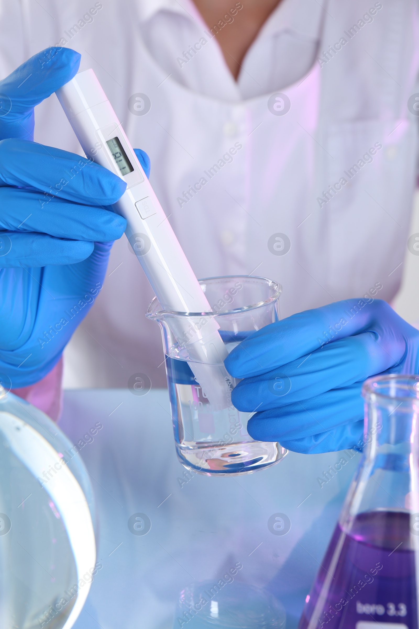 Scientist examining water with nitrate tester at white table in laboratory, closeup Photo of Scientist examining water with nitrate tester at white table in laboratory, closeup