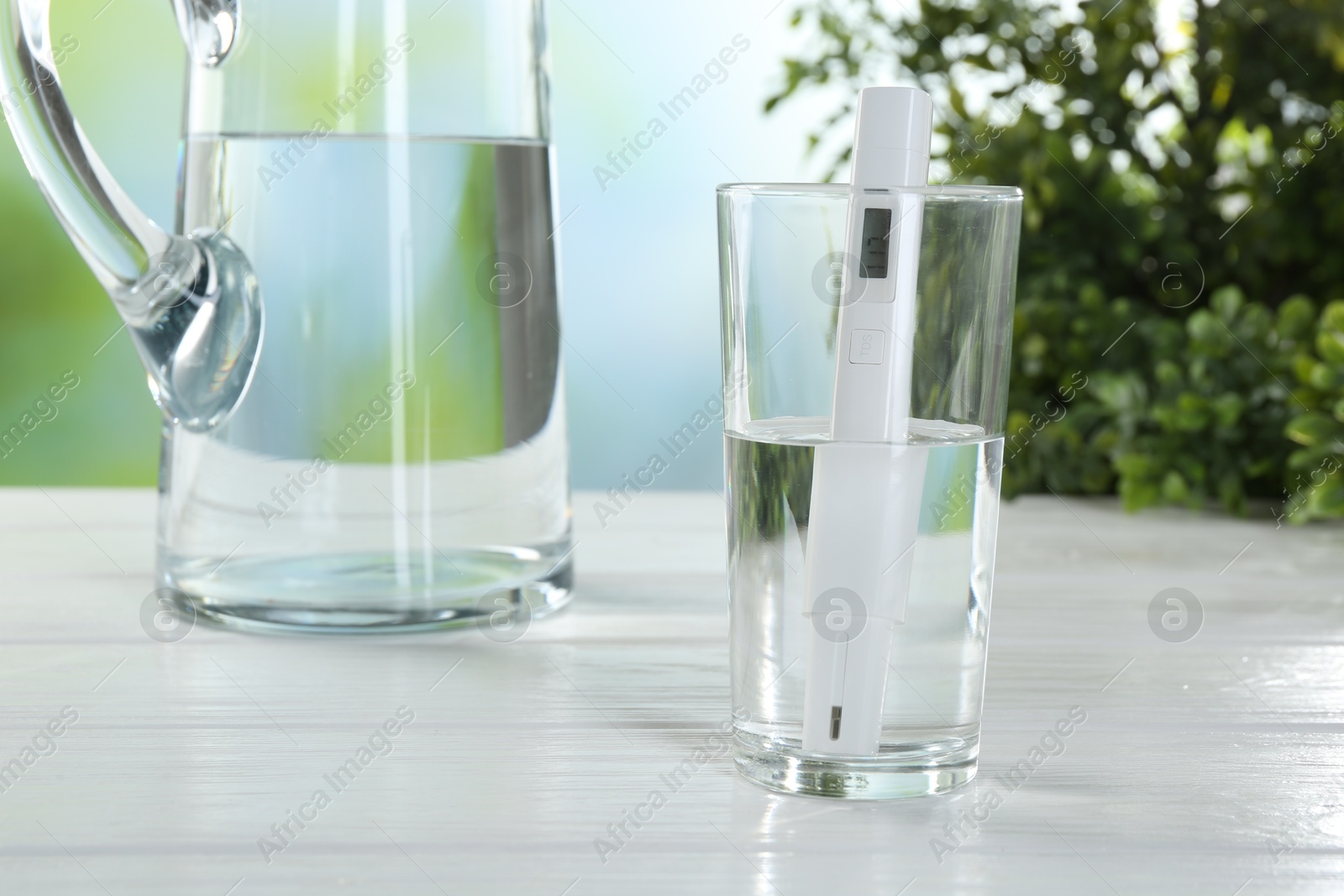 Nitrate tester in glass of water on white wooden table, closeup Photo of Nitrate tester in glass of water on white wooden table, closeup