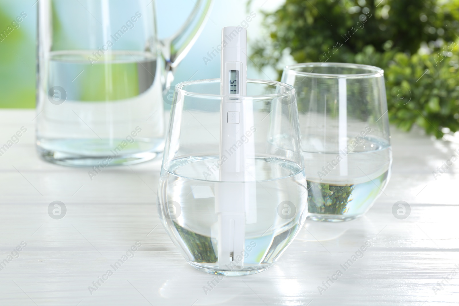 Nitrate tester in glass of water on white wooden table, closeup Photo of Nitrate tester in glass of water on white wooden table, closeup