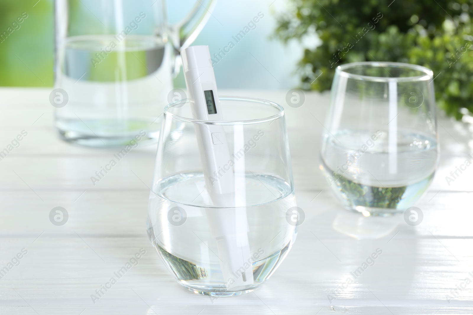 Nitrate tester in glass of water on white wooden table, closeup Photo of Nitrate tester in glass of water on white wooden table, closeup