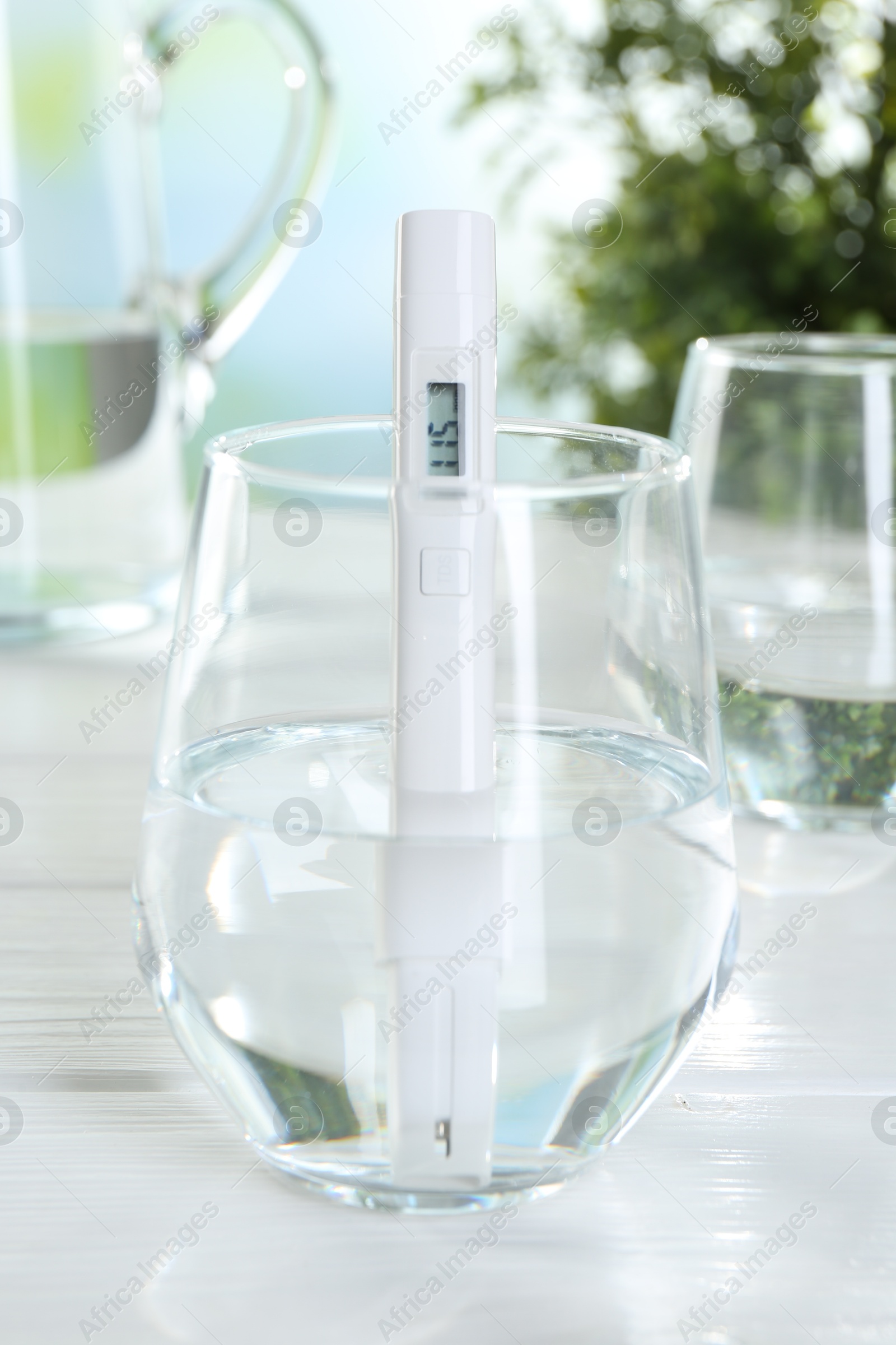 Nitrate tester in glass of water on white wooden table, closeup Photo of Nitrate tester in glass of water on white wooden table, closeup