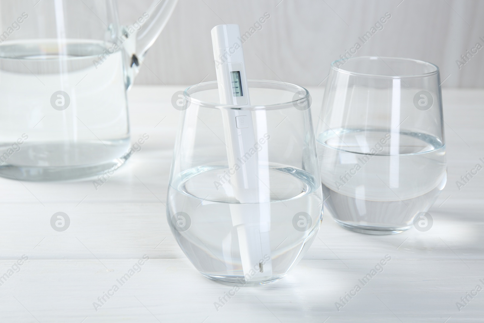 Nitrate tester in glass of water on white wooden table, closeup Photo of Nitrate tester in glass of water on white wooden table, closeup